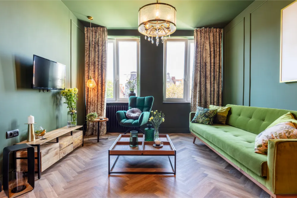 Aufnahme eines ordentlichen und aufgeräumten Wohnzimmers mit vielen grünen Elementen bei Tageslicht